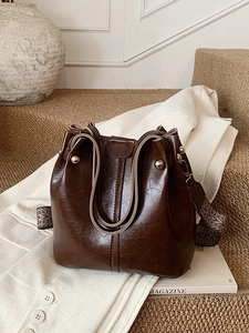 Sac seau marron foncé rétro avec texture cuir vintage et bandoulière géométrique large