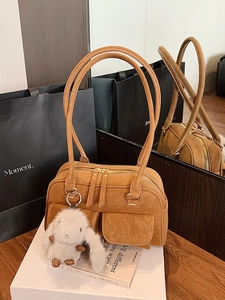 Caramel faux leather bowling bag with plush rabbit charm and decorative topstitching