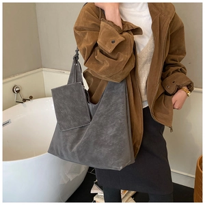Détail du sac cabas en daim gris foncé avec surpiqûres blanches et petite pochette