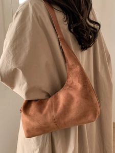 Brown suede hobo shoulder bag for women styled with a beige trench coat for autumn