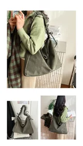 Detail of olive green pleated tote bag featuring gathered cloud shoulder strap texture