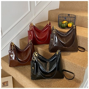 Detail of four glossy leather tote bags with matching mini pouches on stairs
