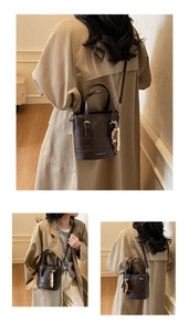 Detail of dark brown leather bucket bag with gold hardware and wooden bead tassel