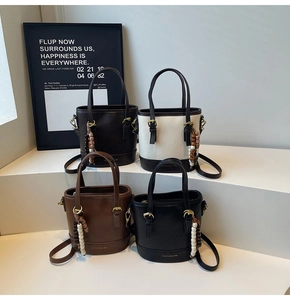 Chic leather bucket bags in four colors featuring unique wooden bead charms and branding