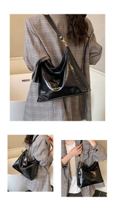 Macro shot of glossy black patent leather tote with gold logo and small square pendant bag