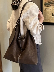 Grand sac cabas rétro marron foncé avec surpiqûres contrastées porté par le mannequin