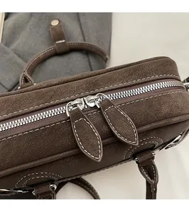Détail du sac Boston vintage marron montrant le zip argenté et les surpiqûres blanches