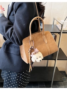 Détail du sac à main caramel avec un charmant chiot en peluche et texture en cuir mat