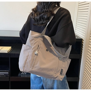 Waterproof nylon tote bag with wide straps shown on model for capacity visualization