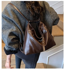 Detail of vintage brown leather tote bag with silver buckle and adjustable shoulder strap