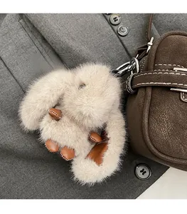 Détail d'un porte-clés lapin en peluche avec accents en cuir sur un sac à main