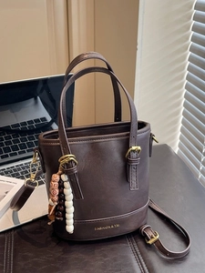 Dark brown PU leather bucket bag with top handles, crossbody strap and beaded charm