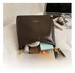 Macro view of dark brown patent leather tote bag interior showing spacious capacity