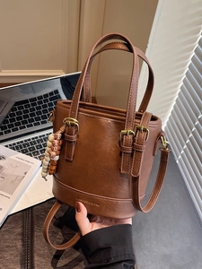 Brown vintage PU bucket bag with wooden bead charm and gold buckles, handheld style