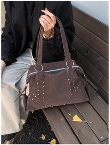 Detail of dark brown tote bag with vintage suede texture and silver stud accents