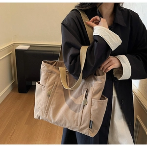 Close-up of khaki waterproof nylon tote bag with functional pockets and wide straps