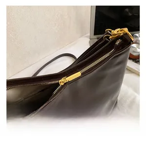 Close-up of deep brown leather tote bag with premium gold zipper and hardware details