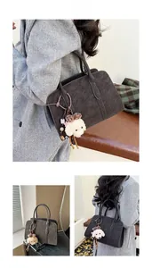 Détail du sac cabas mat marron foncé avec charme en peluche de chiot et doubles anses