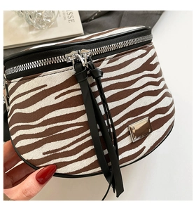 Detail der Schultertasche mit Zebramuster, Silberbeschlägen und Quasten-Reißverschluss
