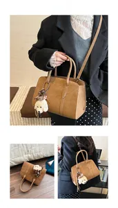 Sac cabas en cuir marron foncé texture litchi avec breloque peluche et bandoulière