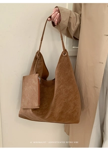 Detail of dark brown retro hobo tote bag with a small matching zipper pouch for women
