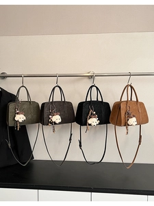 Détail de quatre sacs à main texturés en vert, café, noir et camel avec breloques chiot