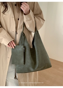 Deep green retro tote bag with matching pouch worn by model in beige trench coat