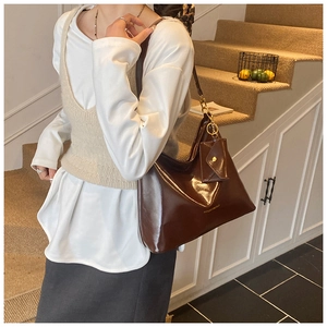 Detail of dark brown tote bag with glossy finish and matching small hanging pouch