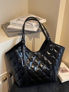 Large black quilted faux leather tote bag with glossy finish and silver buckles