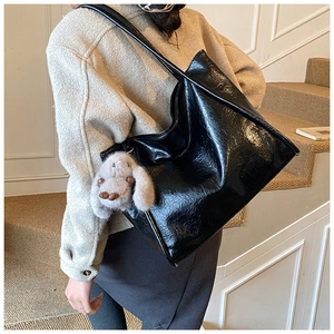 Nahaufnahme der schwarzen Lack-Tote-Bag mit einem süßen Plüsch-Hasen-Anhänger