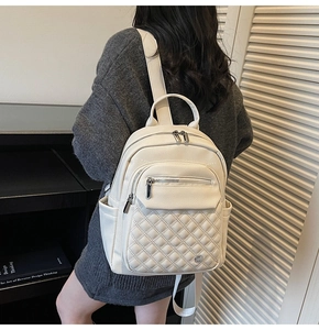 Vista dettagliata dello zaino bianco in ecopelle trapuntata indossato da una modella