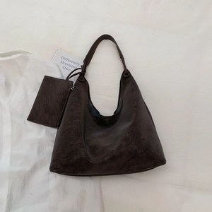 Detail of vintage dark brown tote bag showing crinkle leather texture and mini coin purse