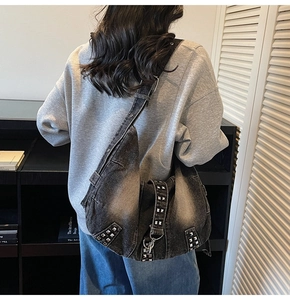 Détail du sac hobo en jean délavé avec rivets argentés carrés et bandoulière réglable