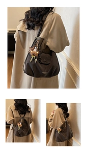 Detail of large dark coffee leather tote with cute bear charm and gold fashion logo