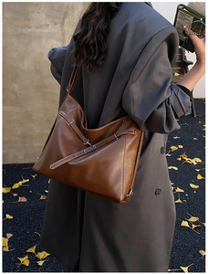 Outdoor shot of a vintage brown large-capacity tote bag with sleek shoulder straps