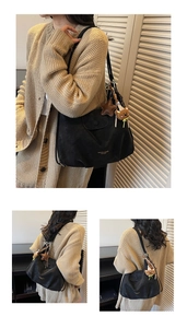 Detail of matte black tote bag with star pendant, plush bear charm and buckle closure