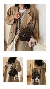 Détails du sac bandoulière en daim marron foncé avec surpiqûres blanches et charme de lapin