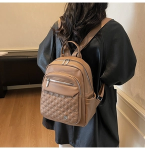 Zaino in pelle marrone con dettagli trapuntati a rombi indossato da una modella