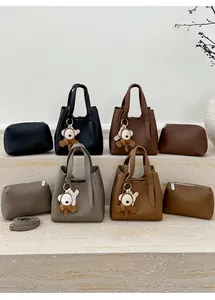Detail of four textured leather bucket bags with pouches and plush monkey charms