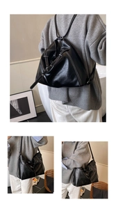Detail of black PU leather tote with white contrast stitching and dual-strap design