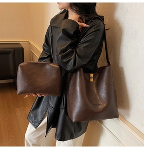 Detail of dark brown bucket bag set with textured matte leather and golden swivel lock