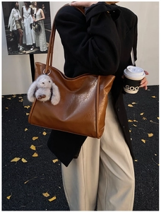 Braune Tote-Bag aus Öl-Wachsleder mit grauem Plüschhasen-Anhänger im herbstlichen Streetstyle