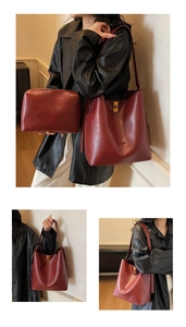Detail of dark red bucket bag set with textured leather and gold square clasp buckle