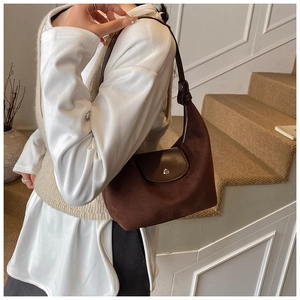 Dettaglio borsa sottobraccio in pelle scamosciata marrone con patta in pelle e fibbia