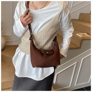 Dettaglio della borsa a tracolla vintage marrone con patta in pelle e chiusura a scatto