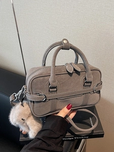 Chic grey suede tote bag with top handles, crossbody strap, and plush rabbit charm