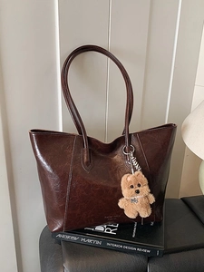 Vintage brown leather tote bag with glossy finish and cute teddy bear charm for women