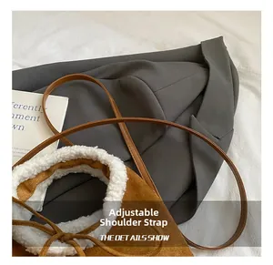 Detail of adjustable leather strap on brown suede crossbody bag with soft faux shearling trim