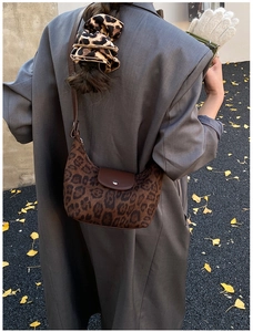 Dettaglio borsa a spalla leopardata con patta in pelle e elastico per capelli abbinato