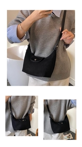 Dettaglio della borsa a mezzaluna in nylon nero con patta in pelle e bottone a scatto
